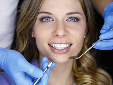 young female patient having her teeth examined